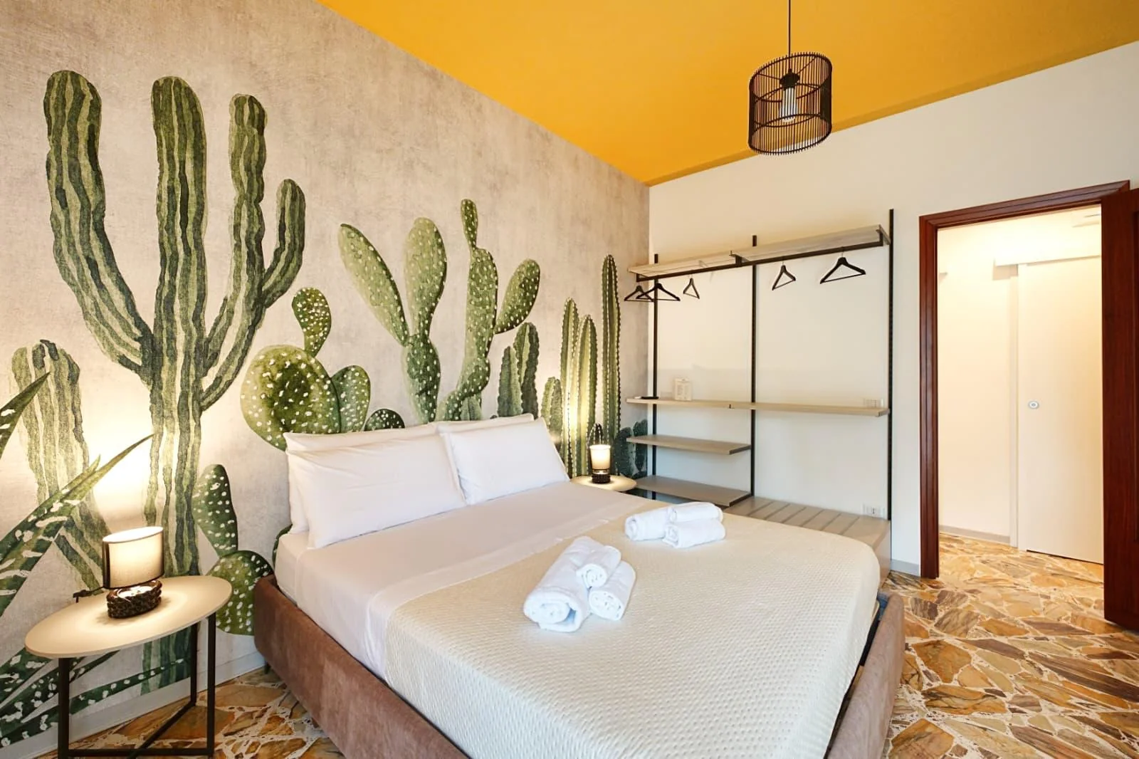La camera da letto di Casalicia, con arredi curati e parete decorata con cactus