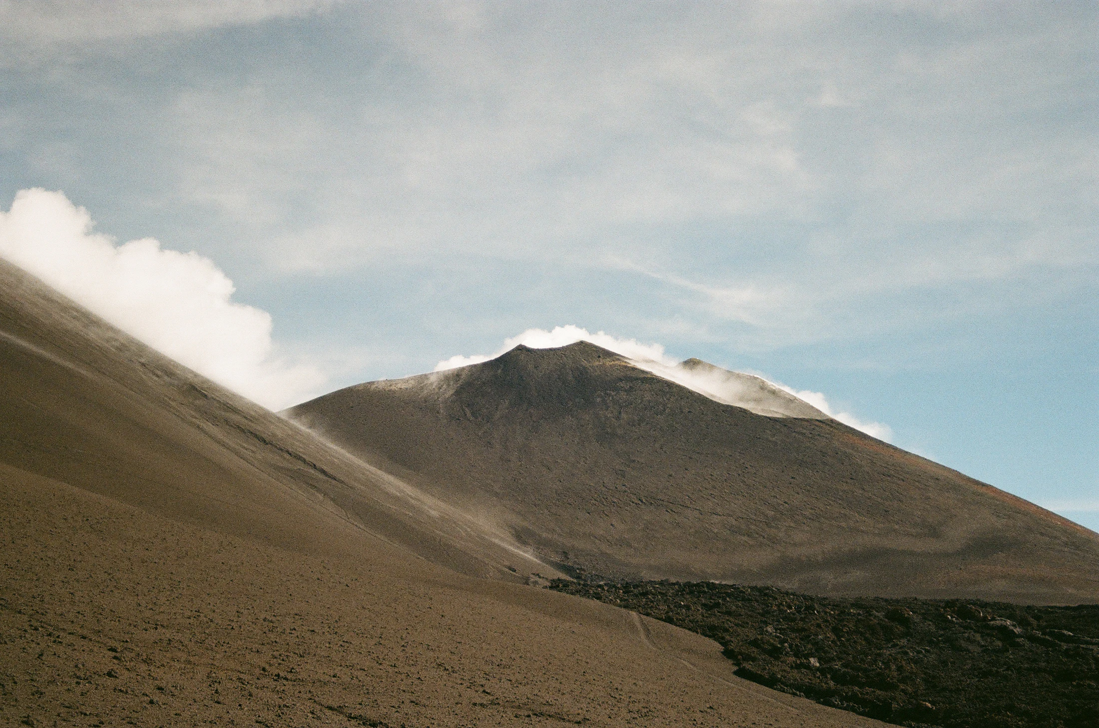 Mount Etna's volcanic slopes under a cloudy sky